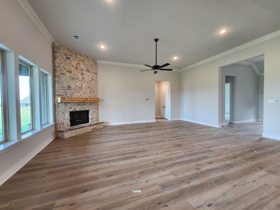 2305 Gypsum Street Krum, TX 76249 - Photo 13 of 22 Spacious living area featuring a floor-to-ceiling stone fireplace with a wood mantle, wood-finish flooring, recessed lighting, and a ceiling fan