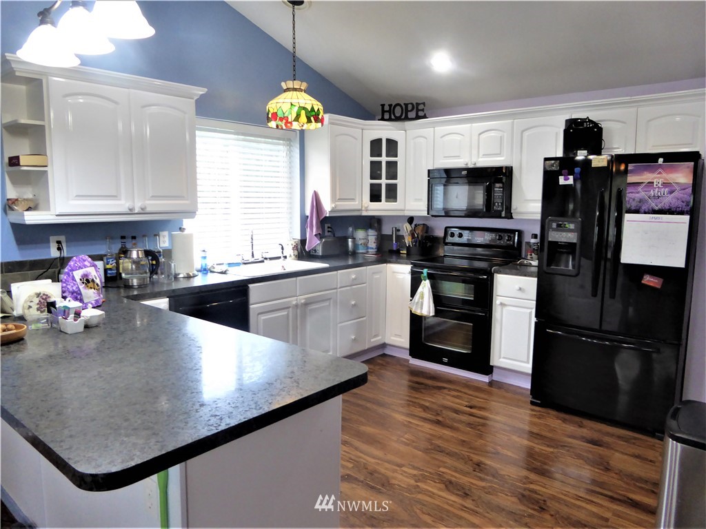 8637 194th Avenue Southwest Rochester, WA 98579 - Photo 7 of 37 a kitchen with stainless steel appliances granite countertop a sink a stove and a refrigerator