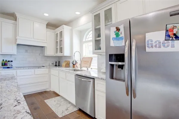 a kitchen with stainless steel appliances granite countertop a refrigerator and a stove
