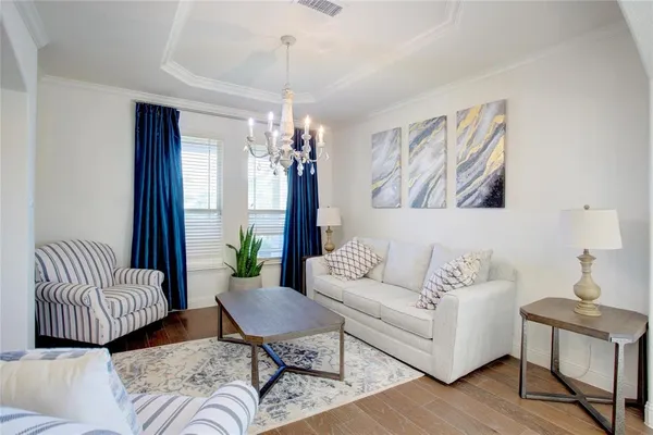 a living room with furniture and a chandelier