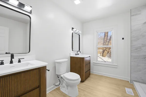 a bathroom with a sink a toilet and mirror