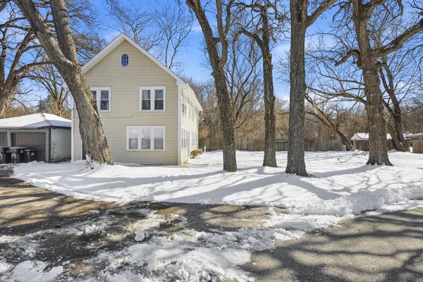 a front view of a house with a yard and covered with snow