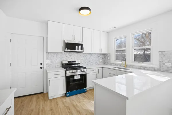 a kitchen with stainless steel appliances granite countertop a stove a sink and a refrigerator