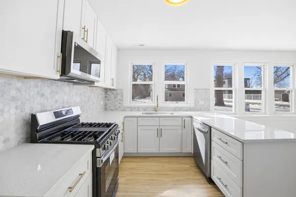 a kitchen with stainless steel appliances a sink stove and cabinets