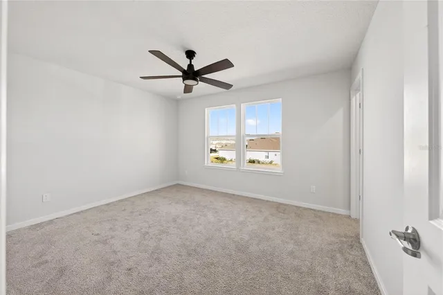 a view of a livingroom with a ceiling fan and window