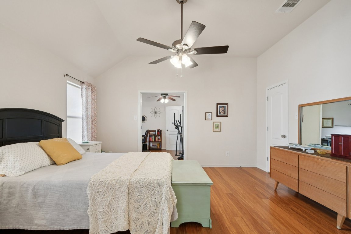 1028 Hot Spring Valley Buda, TX 78610 - Photo 20 of 39 a bedroom with a bed and a chandelier