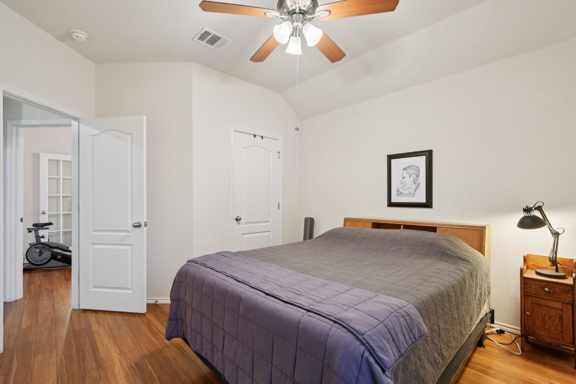 1028 Hot Spring Valley Buda, TX 78610 - Photo 31 of 39 a bedroom with a bed and wooden floor