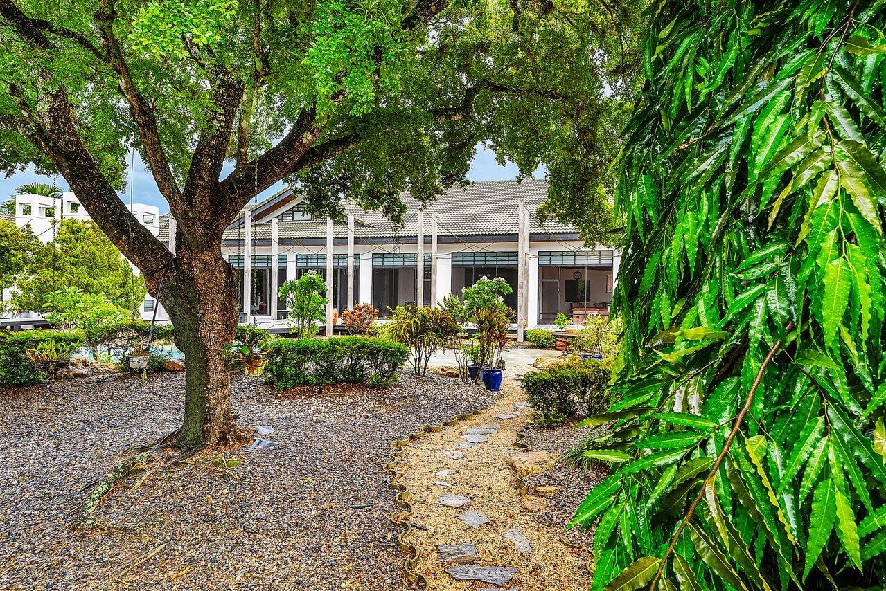 8549 Surrey Lane Boca Raton, FL 33496 - Photo 44 of 106 a front view of a house with a garden and porch