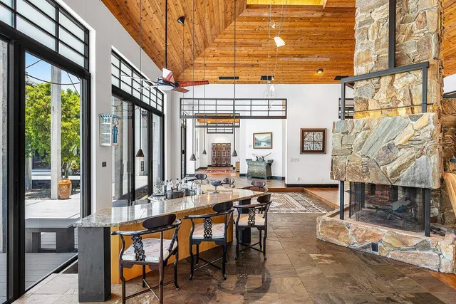 a open kitchen with stainless steel appliances granite countertop a stove a refrigerator a dining table and chairs with wooden floor