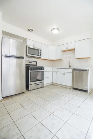 a kitchen with stainless steel appliances granite countertop a refrigerator sink and stove