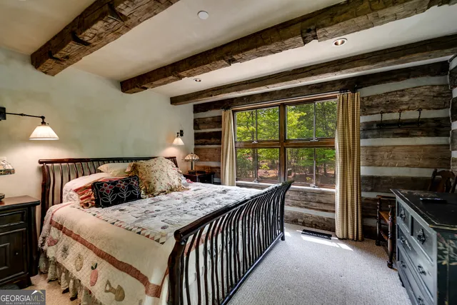 a bedroom with a bed a fireplace and a large window with outer view