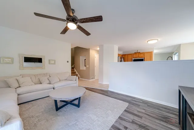 a living room with furniture and a ceiling fan