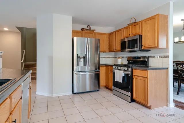 a kitchen with stainless steel appliances granite countertop a stove a refrigerator and a sink
