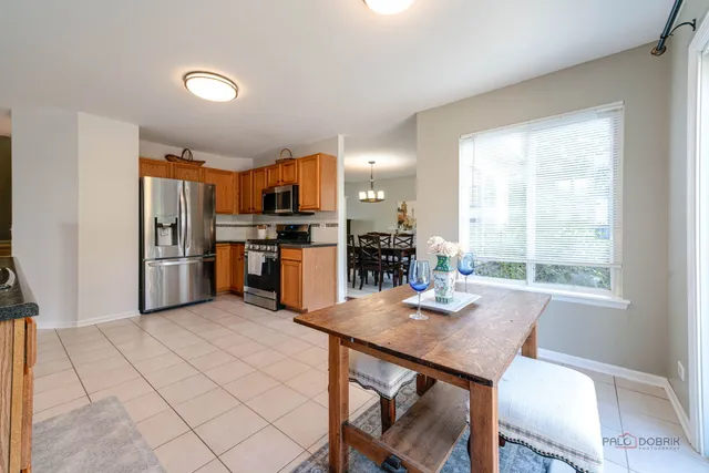 a kitchen with stainless steel appliances a table and chairs in it
