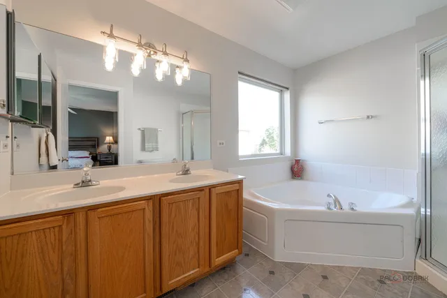 a bathroom with a tub a sink and mirror