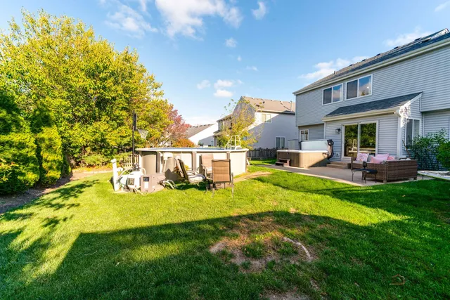 a view of a house with a big yard potted plants and large tree