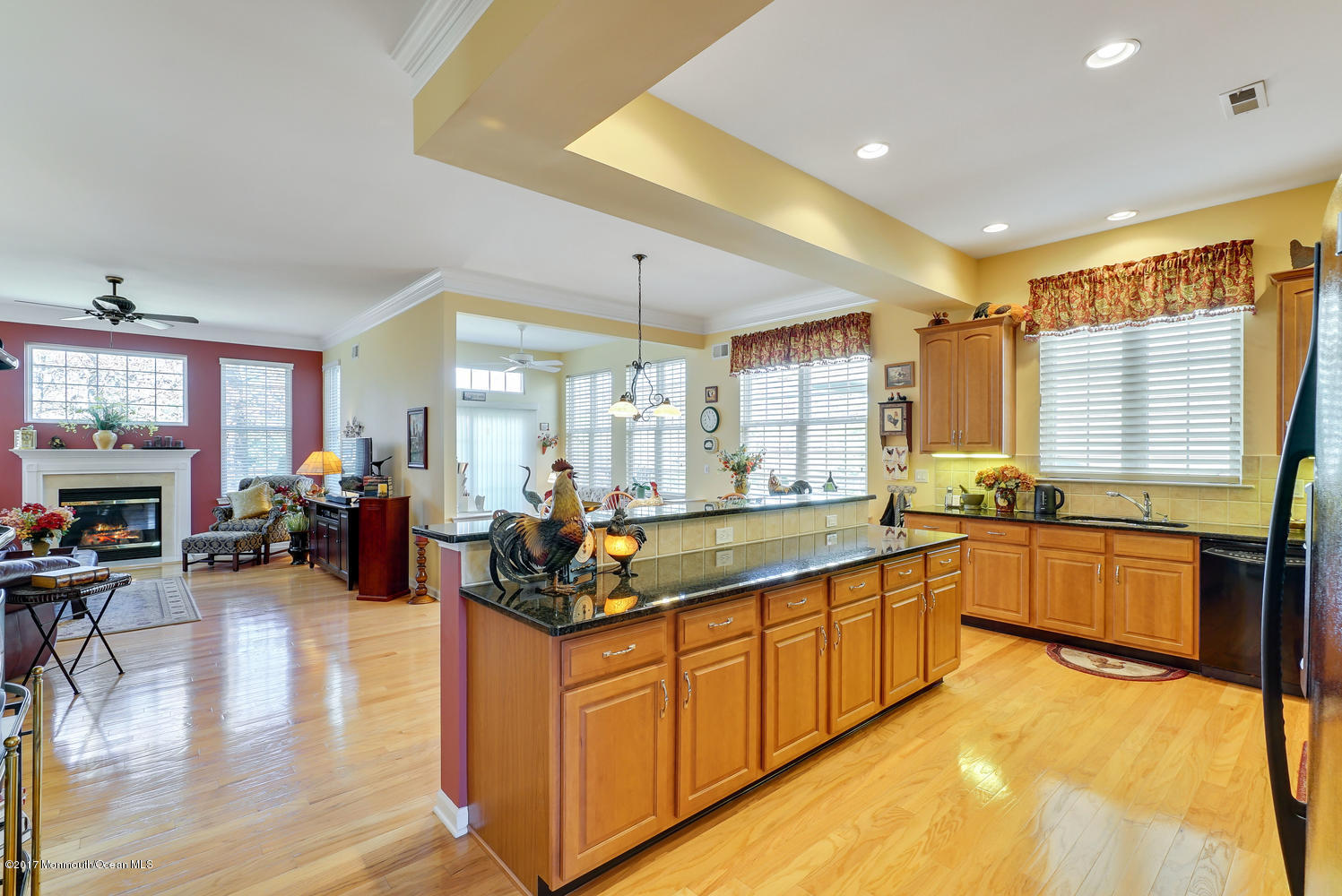 88 Crooked Stick Road Jackson, NJ 08527 - Photo 17 of 41 a large white kitchen with stainless steel appliances granite countertop a refrigerator a sink dishwasher a dining table and chairs with wooden floor