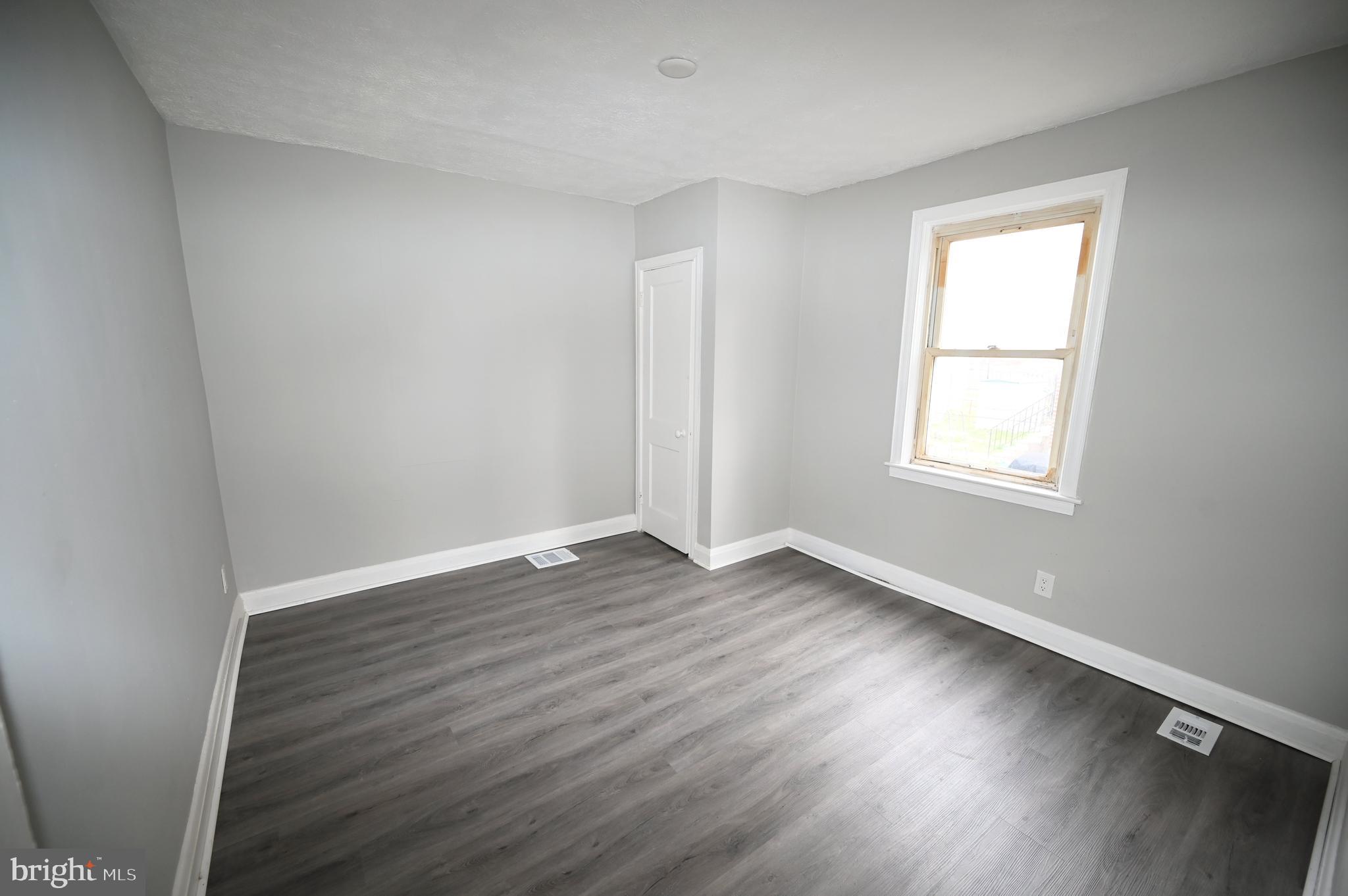 2952 Sollers Point Road, Unit B Dundalk, MD 21222 - Photo 17 of 37 an empty room with wooden floor and windows