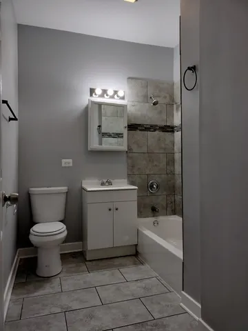 a bathroom with a granite countertop toilet a sink and bathtub