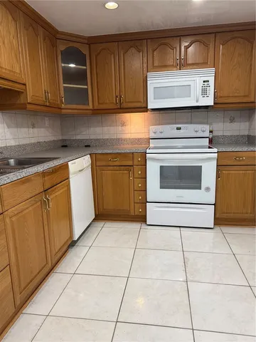 a kitchen with appliances cabinets and a stove top oven