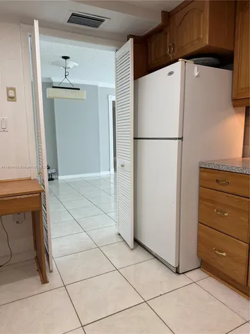 a white refrigerator freezer and a stove sitting inside of a kitchen