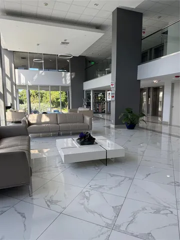 a living room with furniture a fireplace and large windows