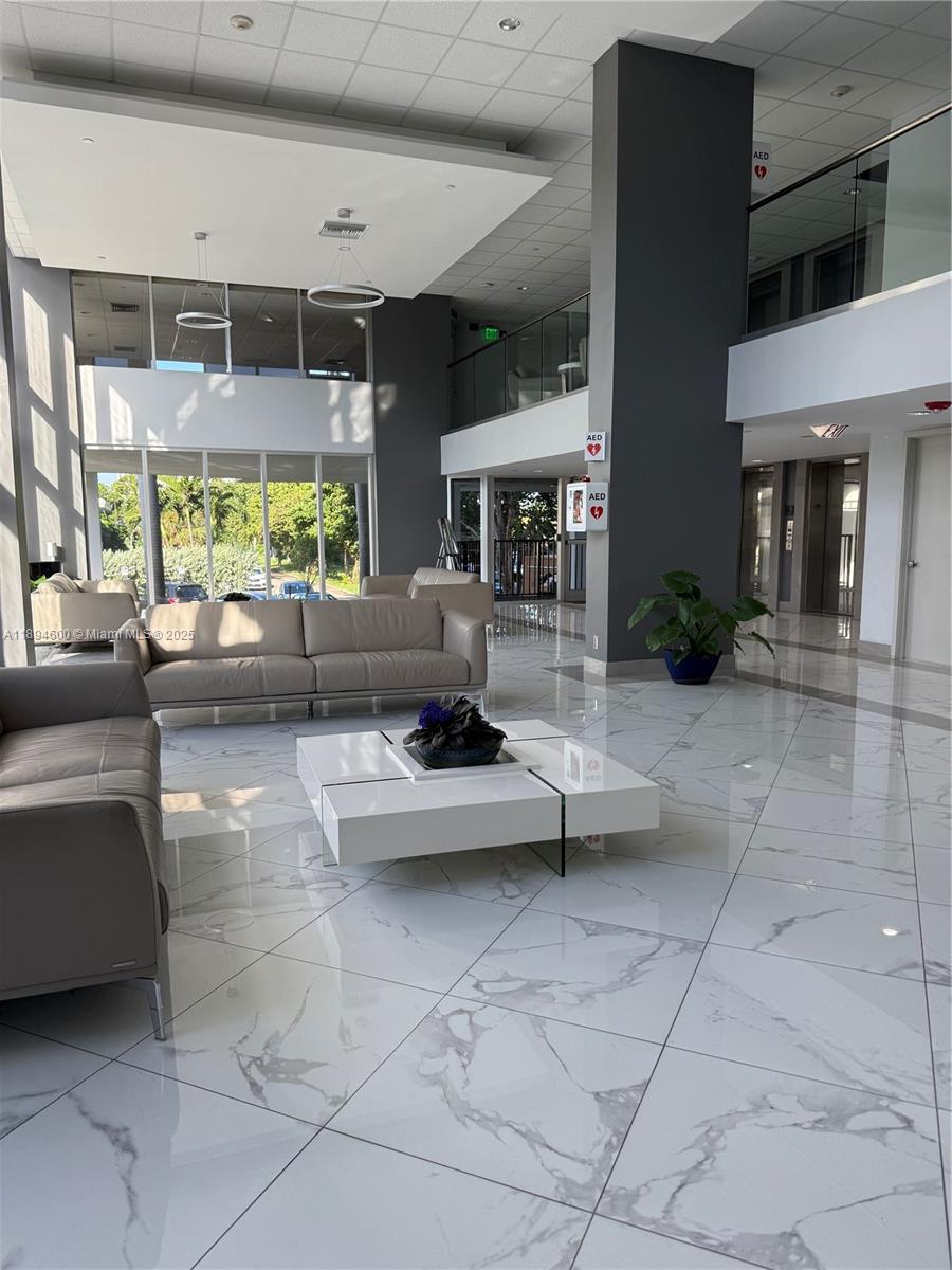 525 North Ocean Boulevard, Unit 920 Pompano Beach, FL 33062 - Photo 4 of 38 a living room with furniture a fireplace and large windows