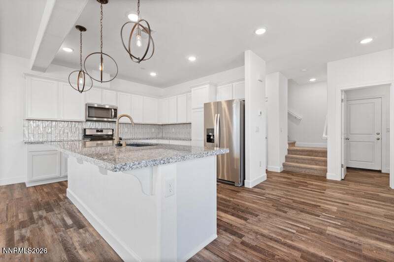 2020 Cradle Mountain Drive, Unit 3 Reno, NV 89523 - Photo 13 of 29 a kitchen with stainless steel appliances granite countertop a white cabinets and wooden floor