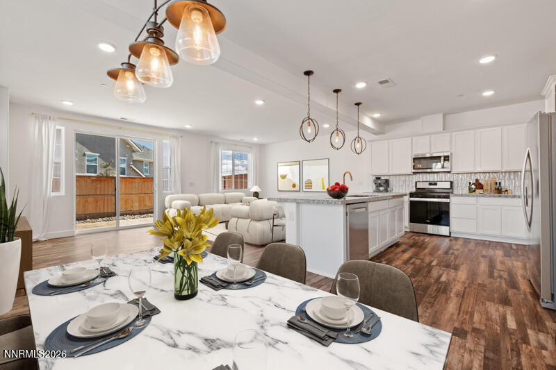 2020 Cradle Mountain Drive, Unit 3 Reno, NV 89523 - Photo 5 of 29 a open kitchen with stainless steel appliances granite countertop a refrigerator a sink dishwasher a dining table and chairs with wooden floor