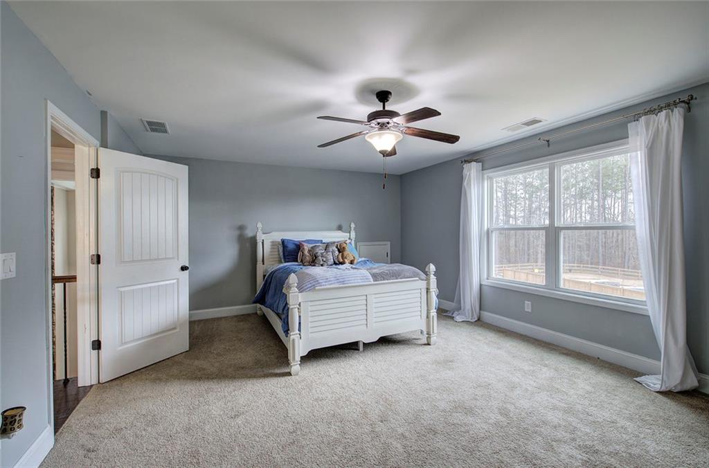 18 Weather View Trail Cartersville, GA 30121 - Photo 42 of 78 a spacious bedroom with a bed and a chandelier