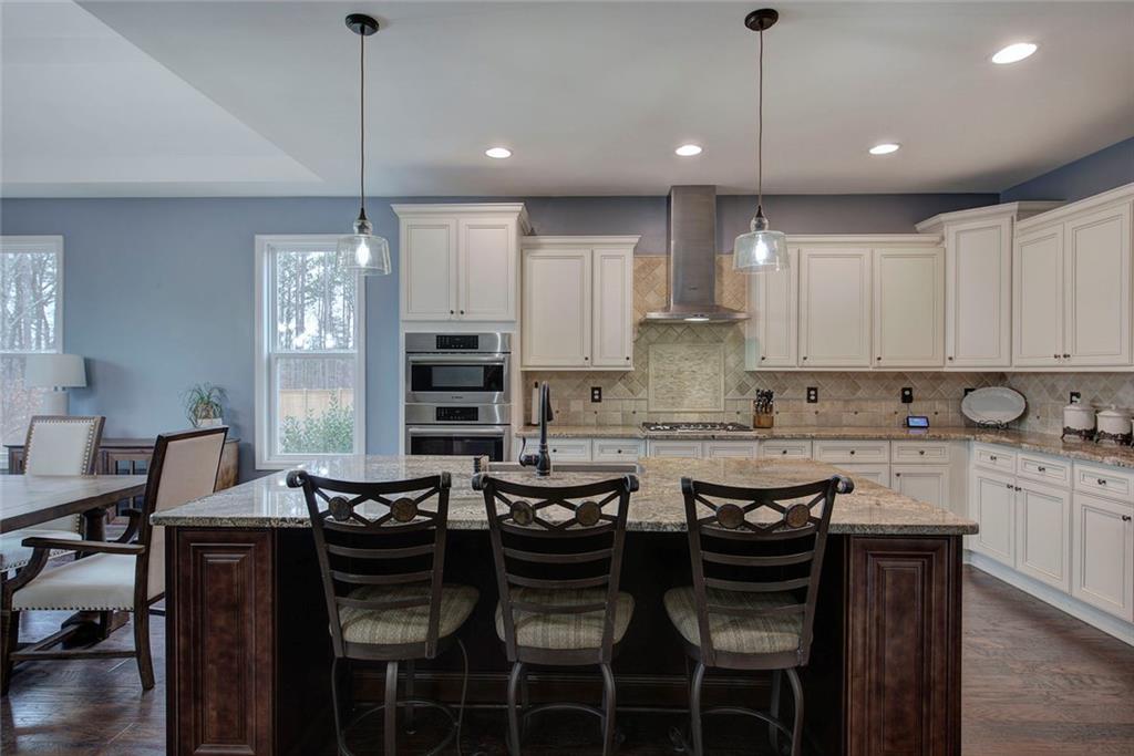 18 Weather View Trail Cartersville, GA 30121 - Photo 9 of 78 a kitchen with granite countertop a table chairs stove and white cabinets