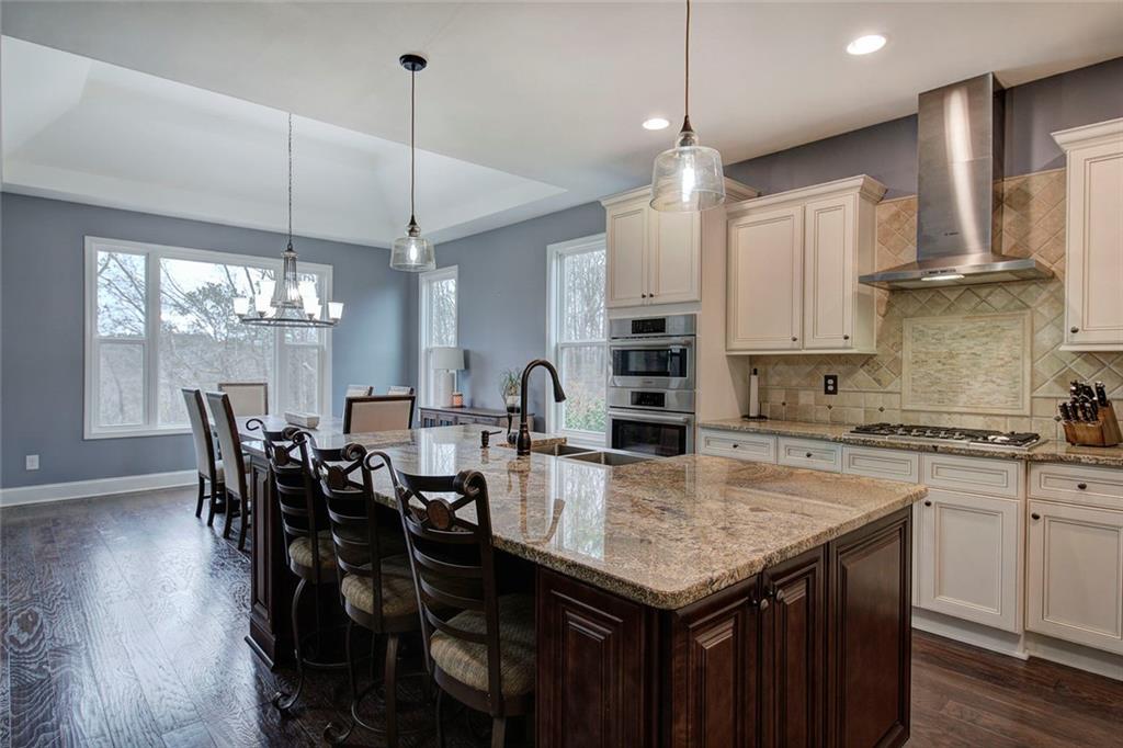 18 Weather View Trail Cartersville, GA 30121 - Photo 10 of 78 a kitchen with granite countertop a table chairs stove and wooden floor