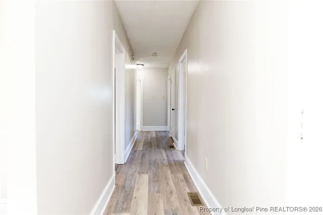 a view of a hallway with wooden floor
