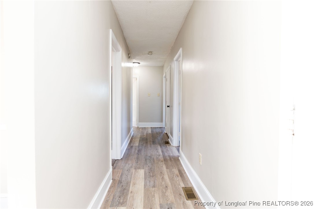 6341 Cliffdale Road Fayetteville, NC 28314 - Photo 13 of 20 a view of a hallway with wooden floor