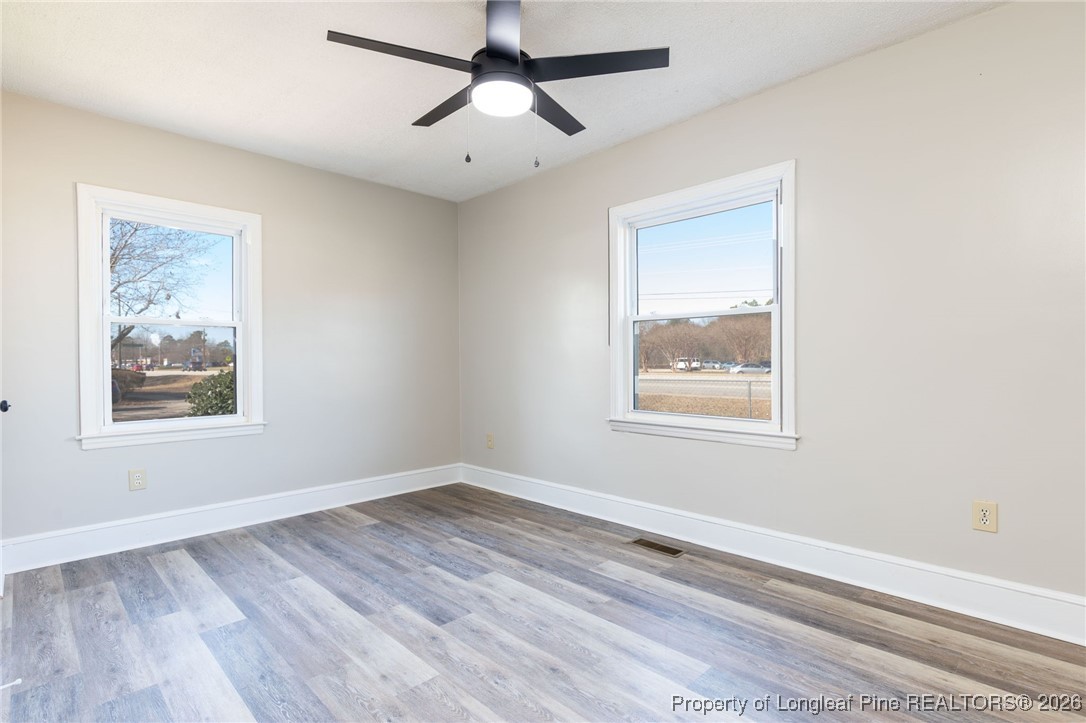 6341 Cliffdale Road Fayetteville, NC 28314 - Photo 16 of 20 a view of an empty room with a window and wooden floor