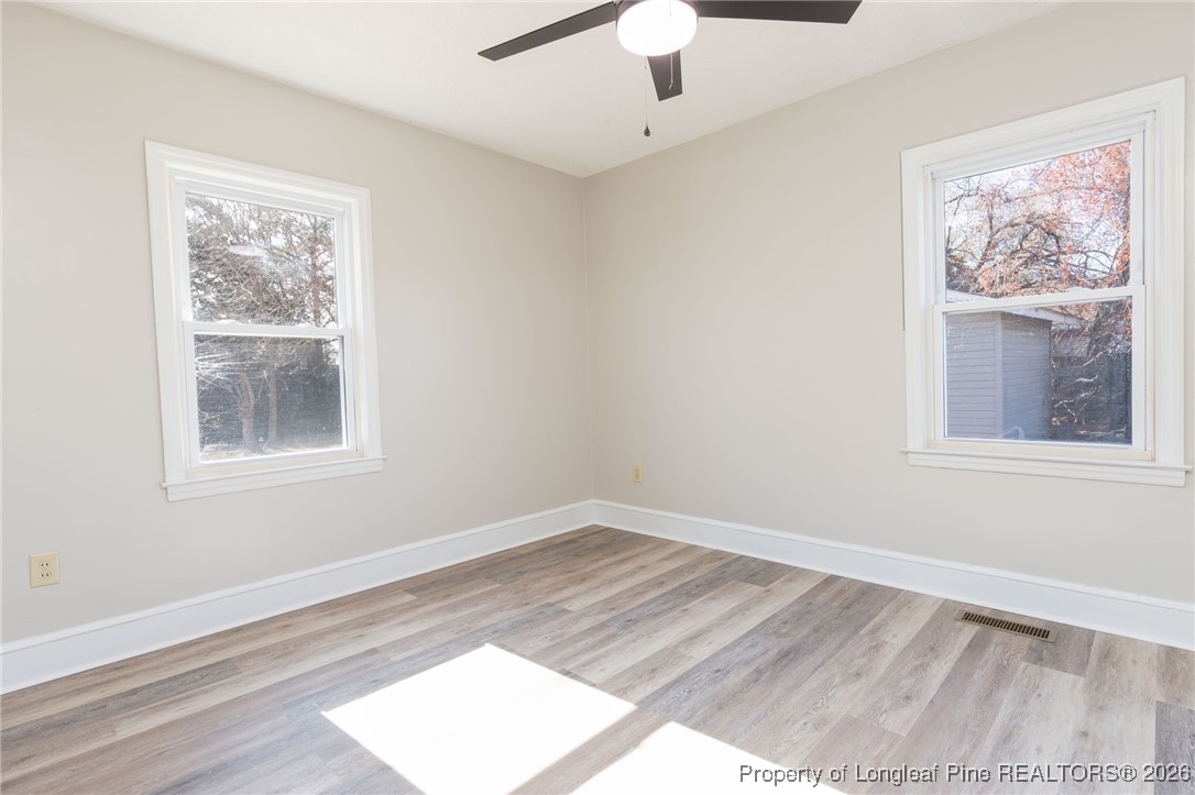6341 Cliffdale Road Fayetteville, NC 28314 - Photo 19 of 20 a view of an empty room with a window and wooden floor