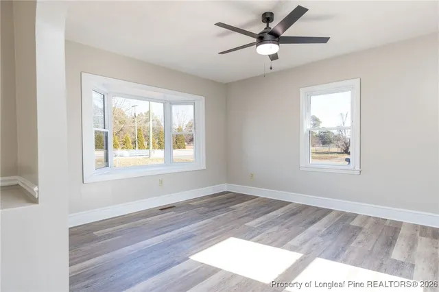 a view of a livingroom with a window and wooden floor