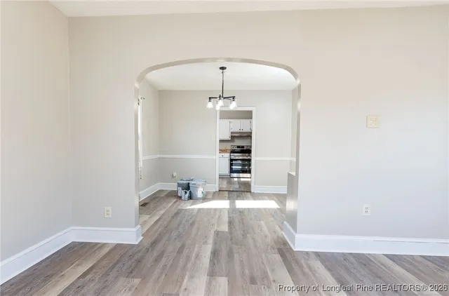 a view of empty room with wooden floor