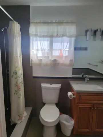 a bathroom with a granite countertop toilet sink and shower