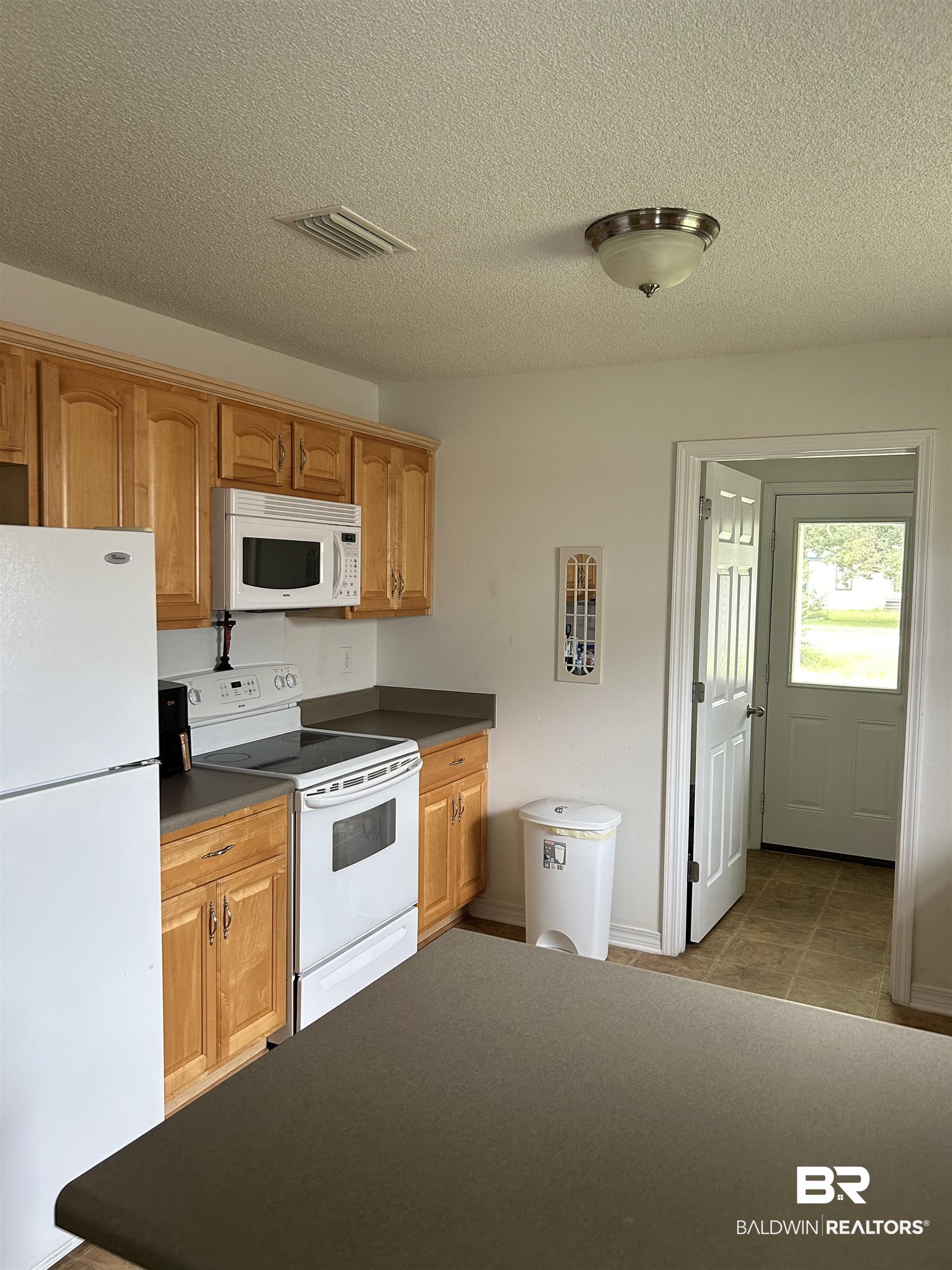 16976 Sugar Loop Foley, AL 36535 - Photo 7 of 16 Kitchen featuring a textured ceiling and white appliances