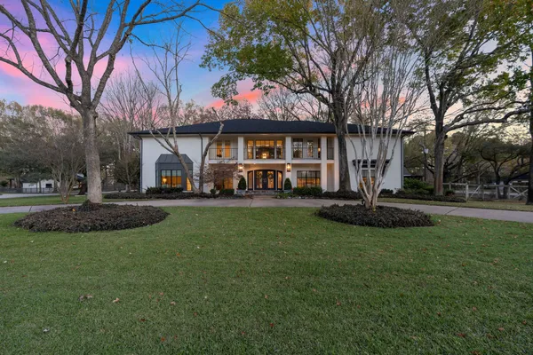a view of a house with a big yard and large trees