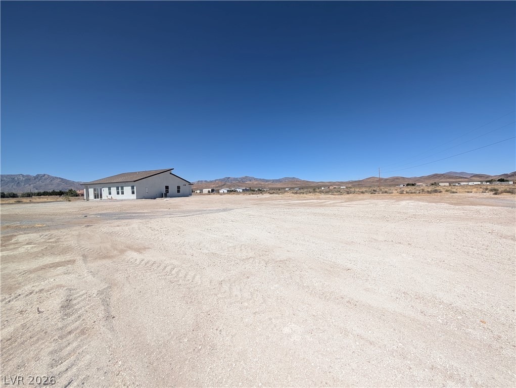4670 Medicine Man Road Pahrump, NV 89048 - Photo 28 of 36 A desert oasis with a single-story home set against a mountain backdrop.