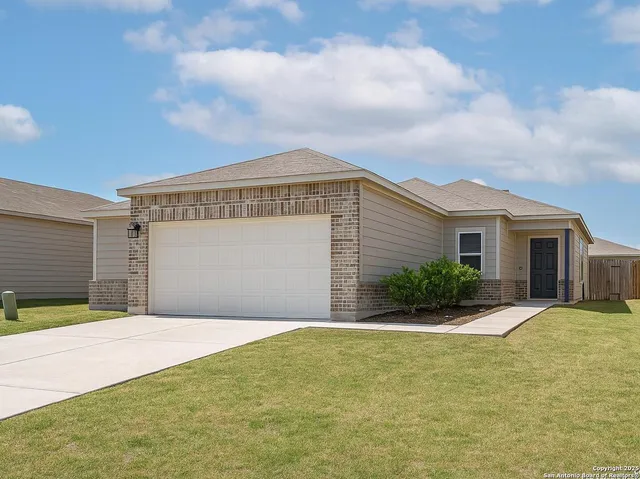 a front view of house with yard and garage