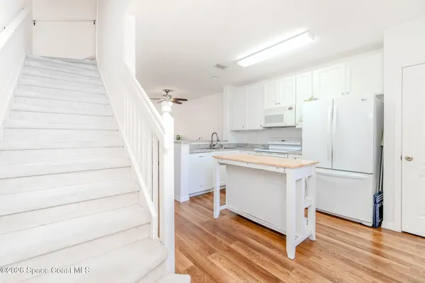 a kitchen with white cabinets and white appliances