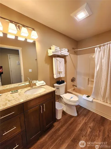 a bathroom with a granite countertop toilet a sink and a mirror