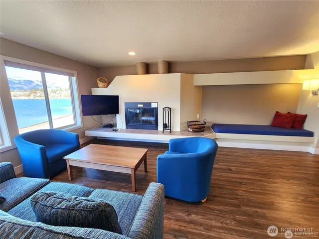 a living room with furniture a fireplace and a large window