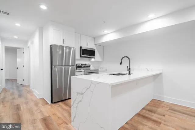 a view of kitchen with kitchen island microwave and stove top oven