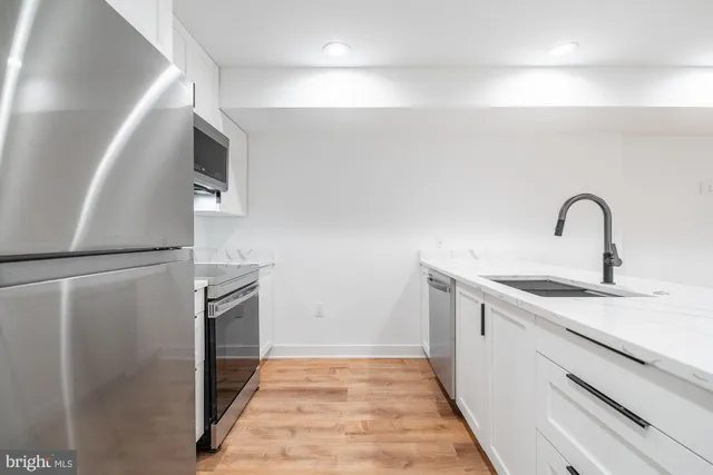 a view of a kitchen with sink a refrigerator and window