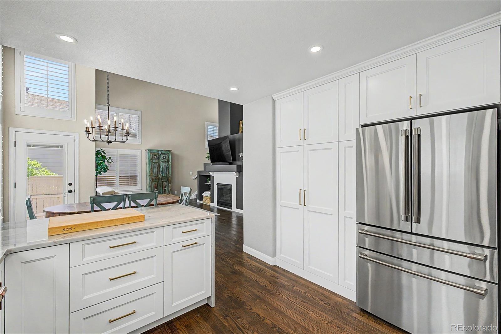 10246 South Spotted Owl Avenue Highlands Ranch, CO 80129 - Photo 13 of 49 a kitchen with white cabinets and stainless steel appliances