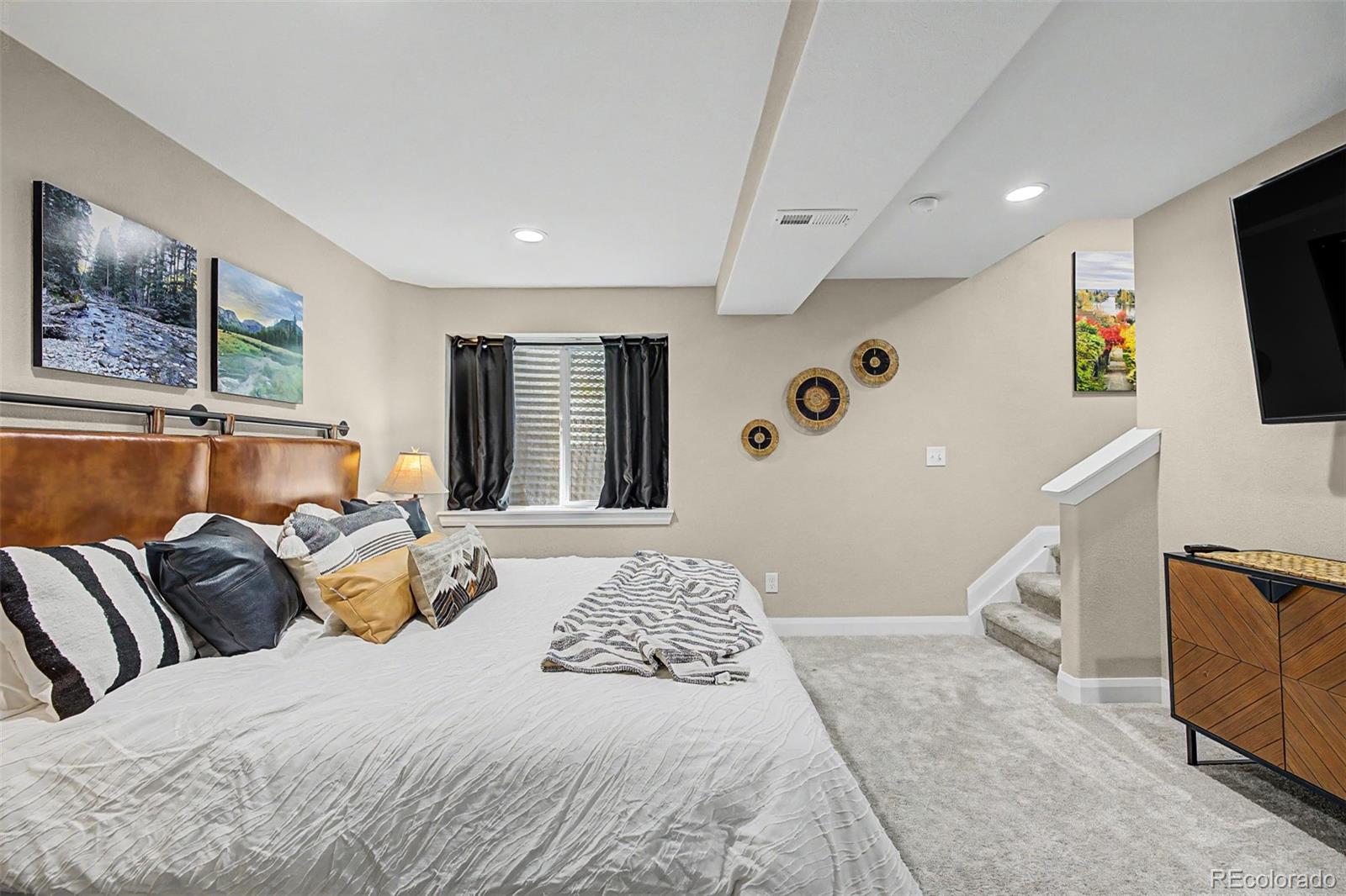10246 South Spotted Owl Avenue Highlands Ranch, CO 80129 - Photo 23 of 49 a bedroom with a bed and flat screen tv